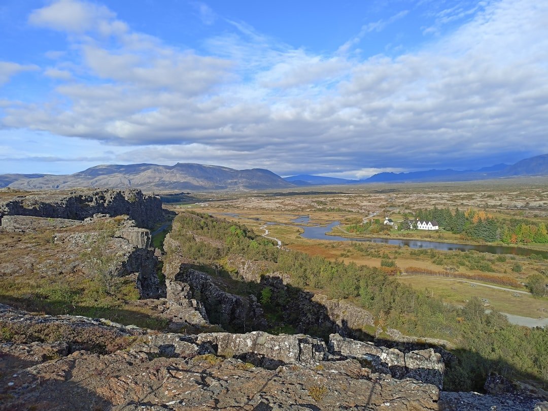 a scenic view of a valley with mountains in the background