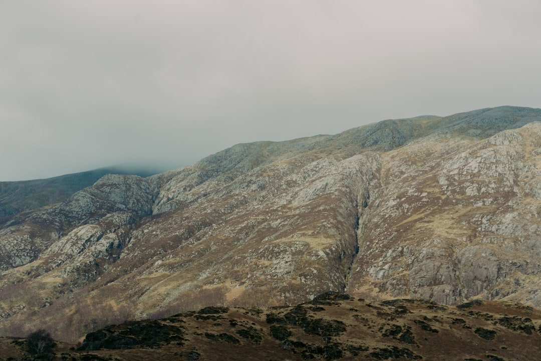 Des montagnes s'élèvent sous un ciel nuageux.