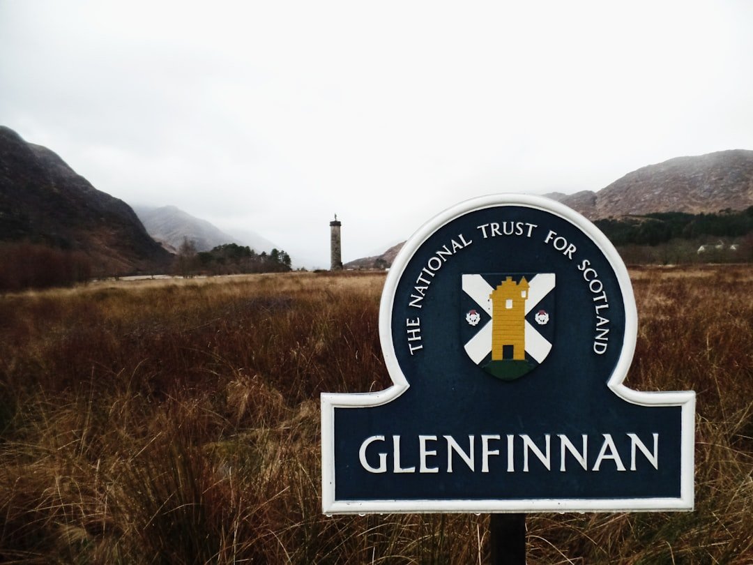 un panneau dans un champ avec des montagnes en arrière-plan