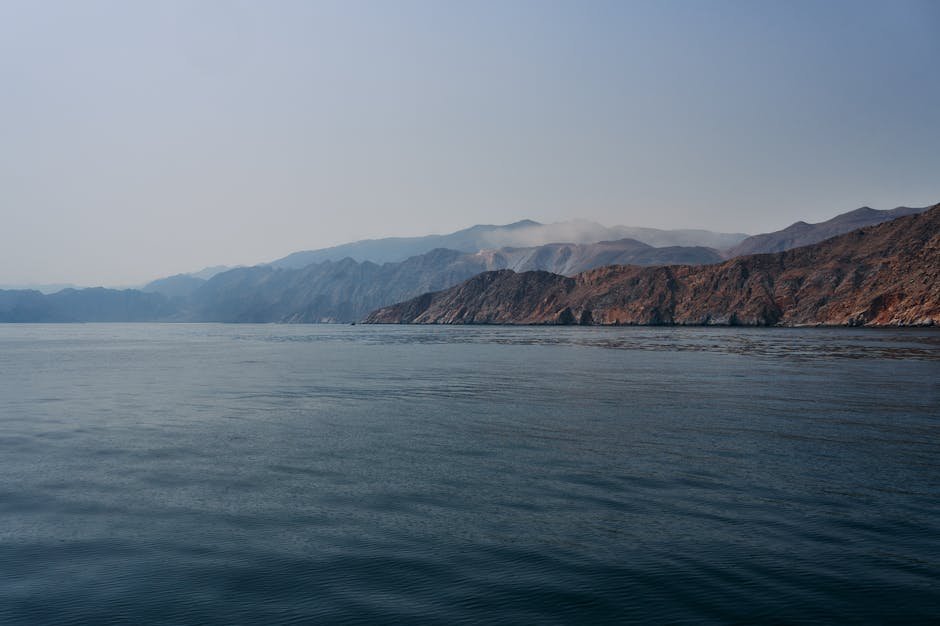 A serene view of the mountains and sea in Musandam, Oman during daylight.