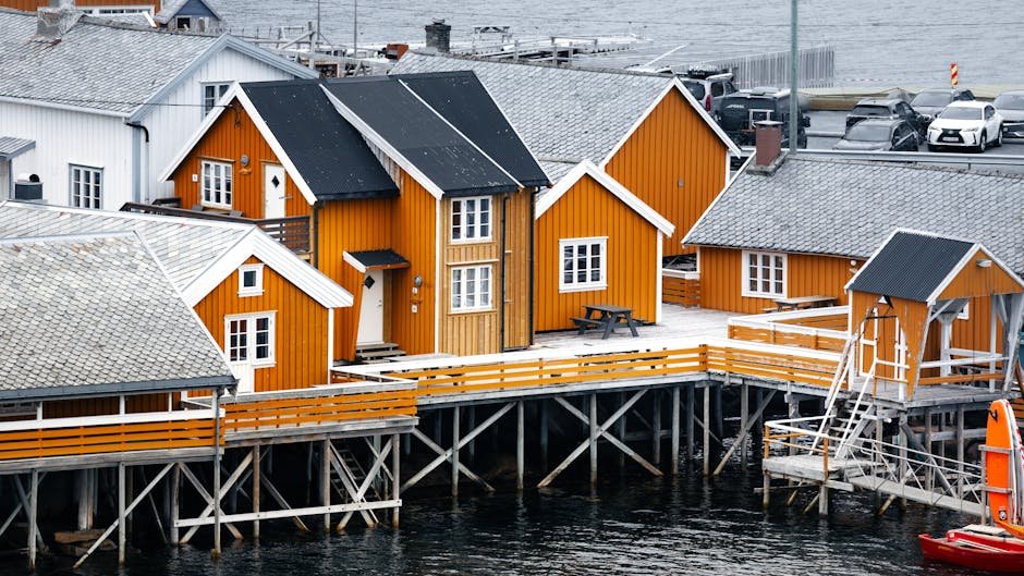Vivaci case di legno arancione su palafitte sul mare in un villaggio norvegese.