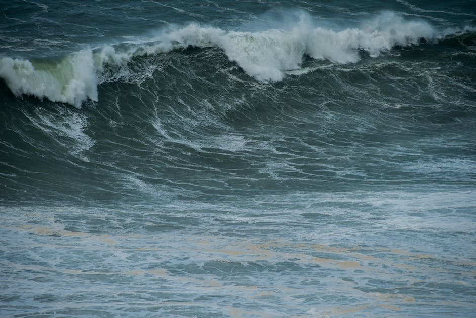 Dramatic ocean waves crashing on the shore in Nazaré, Portugal, showcasing nature's power.