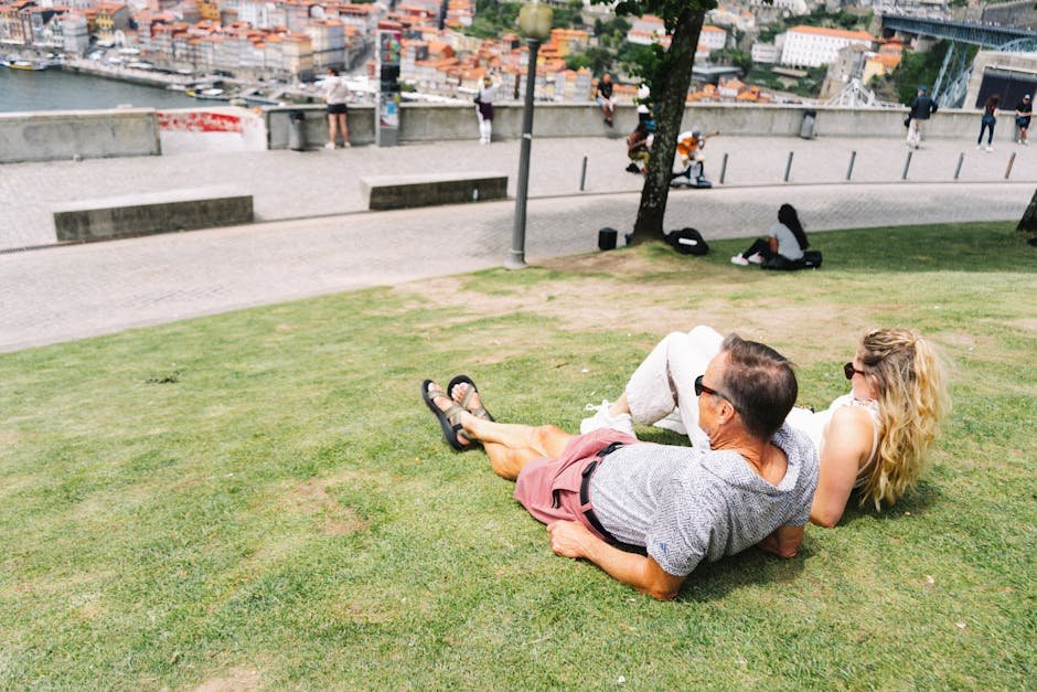 Couple profitant d'une journée ensoleillée au Jardim do Morro, à Porto, Portugal, avec vue sur la ville.
