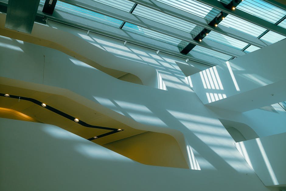 Vue abstraite d'une architecture moderne avec la lumière du soleil projetant des ombres à travers un toit en verre.