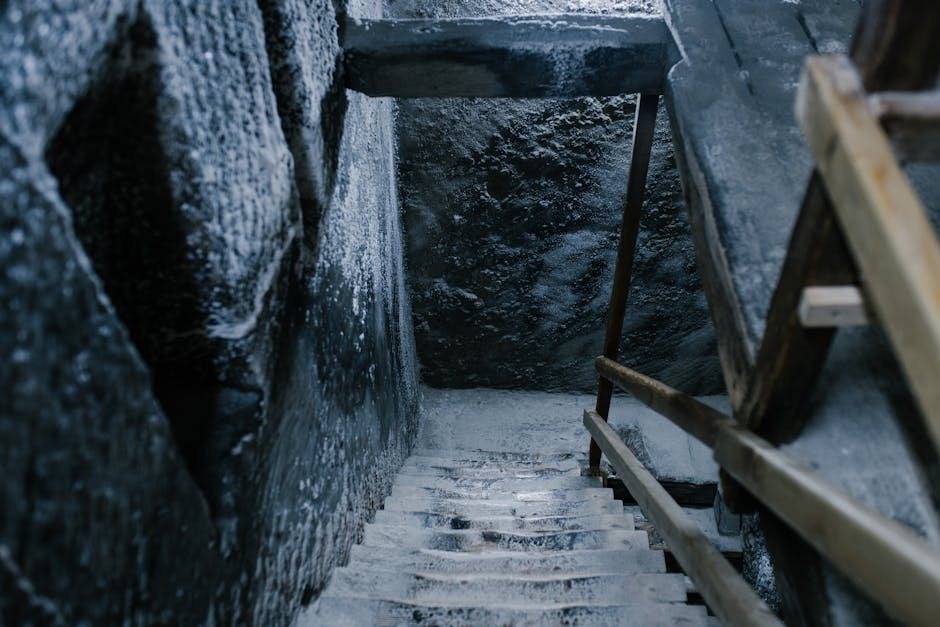 Vue aérienne d'un escalier en pierre ancienne couvert de sel dans une grotte ancienne aux murs usés et rampes en bois dans la chambre d'enregistrement de la mine Salina Turda.