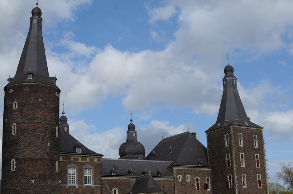 Majestic castle towers in Amsterdam with classic architecture set against a bright blue sky.