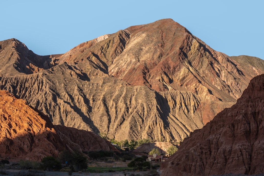 Montagne desertiche illuminate dal sole con formazioni rocciose colorate